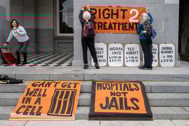 Supporters of Prop. 1 hang banners before the start of a rally at the state Capitol on Jan. 31, 2024. Photos by José Luis Villegas for CalMatters