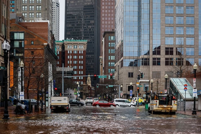 Cars travel through high floodwaters in Boston during high tide. New England residents were greeted with a coastal flood warning for the entire coast of Rhode Island and Massachusetts on up to Maine.