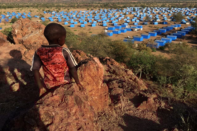 FILE PHOTO: A boy sits atop a hill overlooking a refugee camp near the Chad-Sudan border, November 9, 2023. Hundreds of Masalit families from Sudan's West Darfur state were relocated here months after fleeing to the Chadian border town of Adre, following an ethnically targeted massacre in the city of El Geneina. REUTERS/El Tayeb Siddig/File Photo