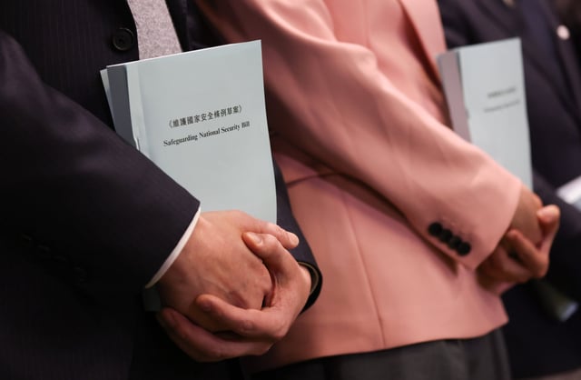 Lawmakers hold copies of the Safeguarding National Security Bill at the Legislative Council in Admiralty. Photo: Yik Yeung-man