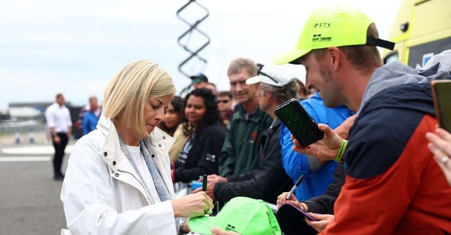 Formula One F1 - British Grand Prix - Silverstone Circuit, Silverstone, Britain - July 9, 2023 Former racing driver Susie Wolff signs her autograph for fans before the race REUTERS/Andrew Boyers