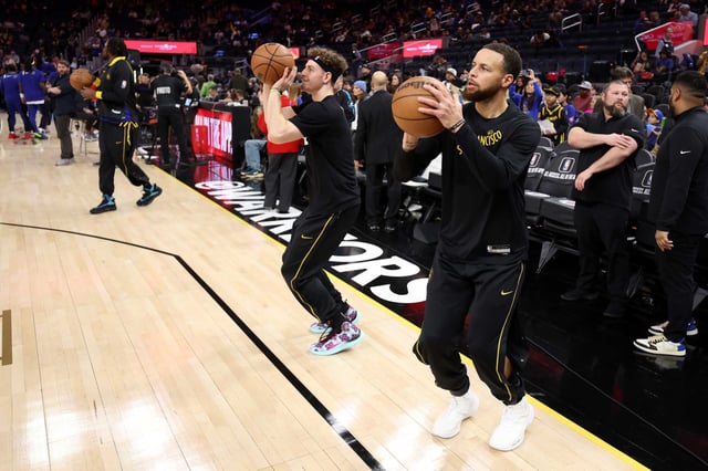 Warriors guards Brandin Podziemski, center, and Stephen Curry warm up before a game against the Clippers at Chase Center on Feb. 14. Curry is expected to return from an ankle injury this week.