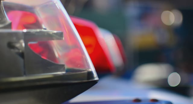 Police car emergency lights close up with NYC taxi in the background.