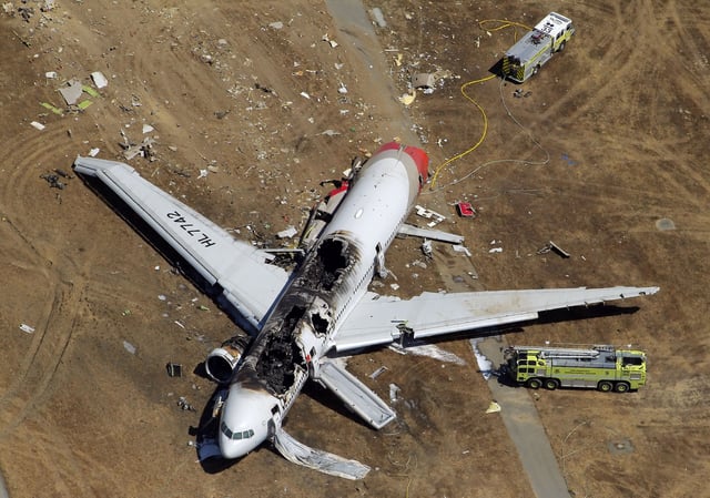 The destroyed fuselage of Asiana Airlines Flight 214 is visible on the runway at San Francisco International Airport after it crashed on landing and burned on Saturday, July 6, 2013.
