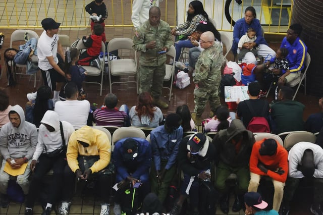 Newly arrived asylum-seekers wait in a holding area at the Port Authority bus terminal in Manhattan before being sent off to area shelters and hotels on May 15, 2023, in New York City.