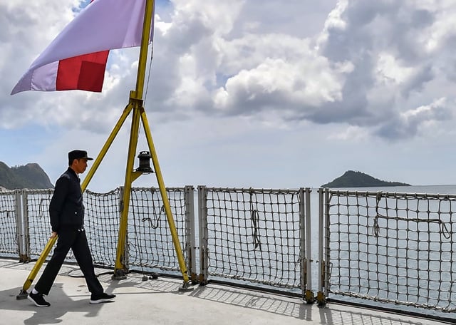 Indonesia’s President Joko Widodo walking past the country’s flag on a navy ship during his visit in January 2020 to a military base in the Natuna islands, which border the South China Sea. Photo: Presidential Palace/AFP