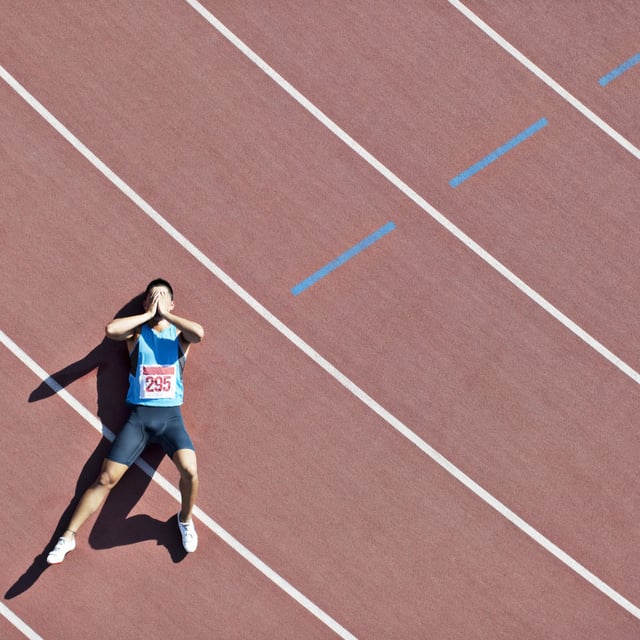 A stock photo shows a runner lying on a track. A new study has found that suicide rates among college athletes have doubled in the last 20 years.