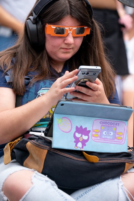 Faralyn Stroop, an anthropology student, works on her school registration while awaiting the eclipse at the University of Texas in Austin, Tenn., Monday, April 8, 2024.