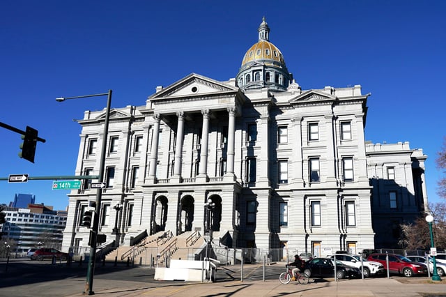 A cyclist rides past Colorado's State Capitol building, in Denver. on Jan. 15, 2021.