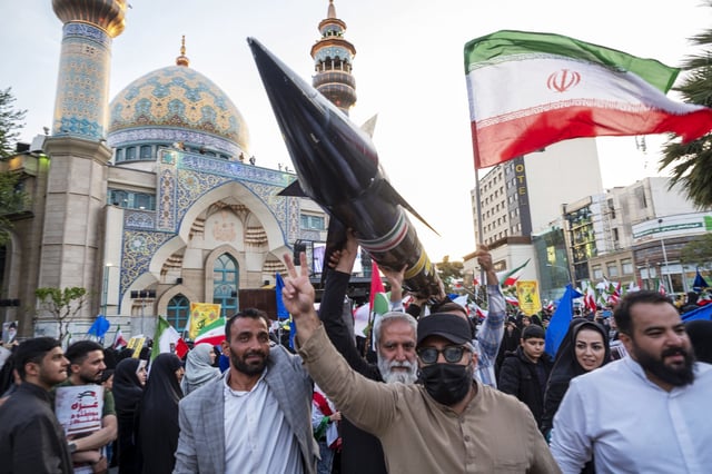 Men carry a model of Iran's first-ever hypersonic missile, Fattah, during celebrations in Tehran on April 15, 2024, following the drone and missile attack against Israel.