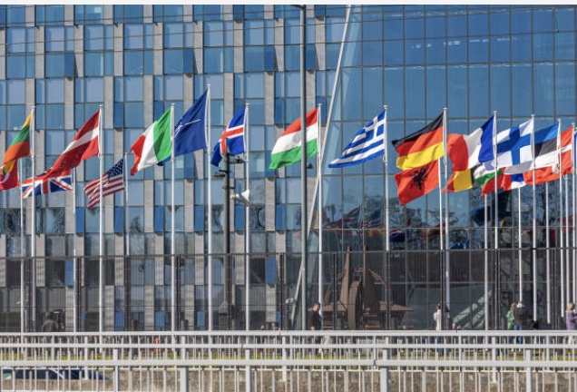 Flag raising ceremony as NATO adds Finland, the 31st member of the North Atlantic Alliance. The Flag of Finland, also called siniristilippu ''Blue Cross Flag'' or Suomen lippu in Finnish is raised and waves in the air in the light wind in front of the NATO headquarters buildings in Brussels during a special ceremony, while outside of the HQ Ukrainians demonstrate against the war with Russia and ask for NATO's support in military gear like F16 fighting aircraft jets. The flags at the flagpoles represent the member states in addition to NATO's flag in the middle. The 31 states are Albania, Belgium, Bulgaria, Canada, Croatia, Czech Republic, Denmark, Estonia, Finland, France, Germany, Greece, Hungary, Iceland, Italy, Latvia, Lithuania, Luxembourg, Montenegro, Netherlands, North Macedonia, Norway, Poland, Portugal, Romania, Slovakia, Slovenia, Spain, Turkey, United Kingdom, United States, The North Atlantic Treaty Organization NATO is an intergovernmental military alliance. Brussels, Belgium on April 4, 2023 (Photo by Nicolas Economou/NurPhoto via Getty Images)