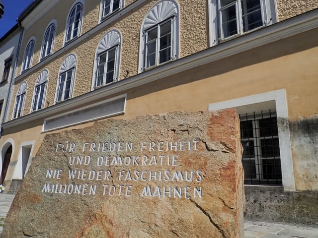 BRAUNAU AM INN, AUSTRIA - 2017/08/30: In front of Hitlers birthplace there is a stone from a stone-quarry in Mauthausen concentration camp where prisoners had to work. "For peace, freedom and democracy. Never more fascism. Millions of dead warn." is written on it.
In a simple yellow house in Salzburger Vorstadt 15, Braunau am Inn, where his parents rented a small flat, Adolf Hitler was born on April 20th 1889. He later became the worst criminal in the history.  In his birthplace in the Austrian town Braunau am Inn they try to forget him. They want to avoid the neo-nazi to make a pilgrimage site from this place. That´s why the state expropriated the building from the owner, Gerlinde Pommer - Angloher, last year, and plan to rebuild it and use it for charitative purposes. (Photo by Jana Cavojska/SOPA Images/LightRocket via Getty Images)