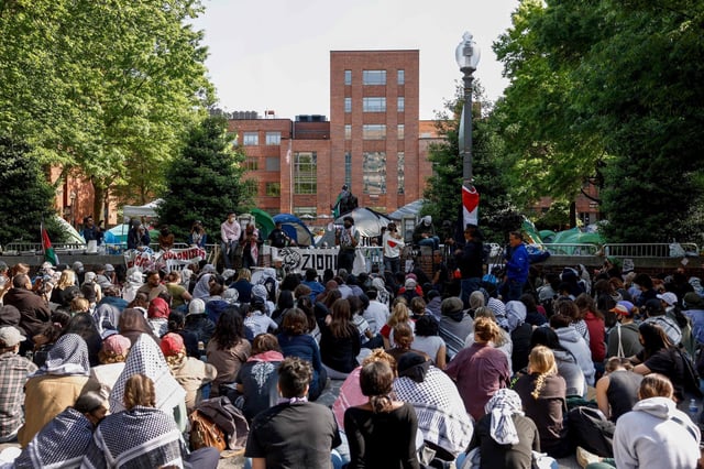 Activists and students listen to speeches on the outskirts of an encampment protest at George Washington University on April 26. Photo: Getty Images via AFP