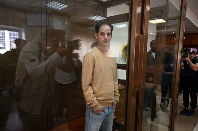 U.S. journalist Evan Gershkovich stands inside a defendants' cage before a hearing in Moscow on Sep. 19, 2023. 
