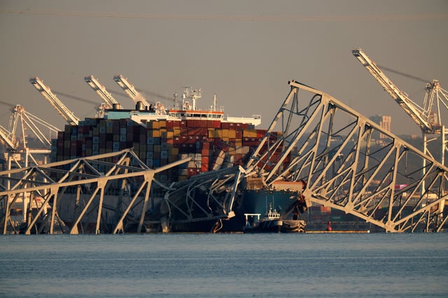 BALTIMORE, MARYLAND - MARCH 29: The cargo ship Dali remains trapped under the twisted remains of the Francis Scott Key Bridge, which was destroyed when the ship collided with it earlier this week, on March 29, 2024 in Baltimore, Maryland. Of the road repair crew who were working on the bridge when the ship hit it at 1:30AM Tuesday, two survivors were pulled from the Patapsco River immediately after the collision, while two bodies were pulled from the water on Wednesday and four people remain missing and are presumed dead after the Coast Guard called off rescue efforts. The accident has temporarily closed the Port of Baltimore, one of the largest and busiest on the East Coast of the U.S.  (Photo by Chip Somodevilla/Getty Images)