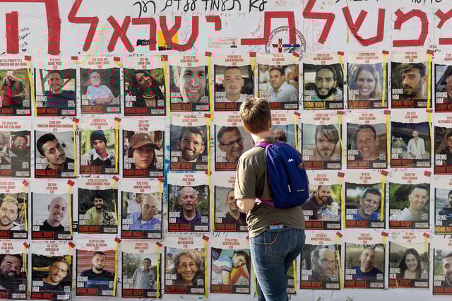 A women looks at photos of hostages held by Hamas in Gaza on May 1, 2024, in Tel Aviv, Israel.
