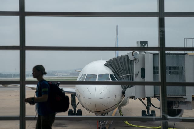 A traveler walks past a United Airlines aircraft, ahead of the July 4th holiday, at Ronald Reagan Washington National Airport in Arlington, Virginia, on July 1, 2023.
