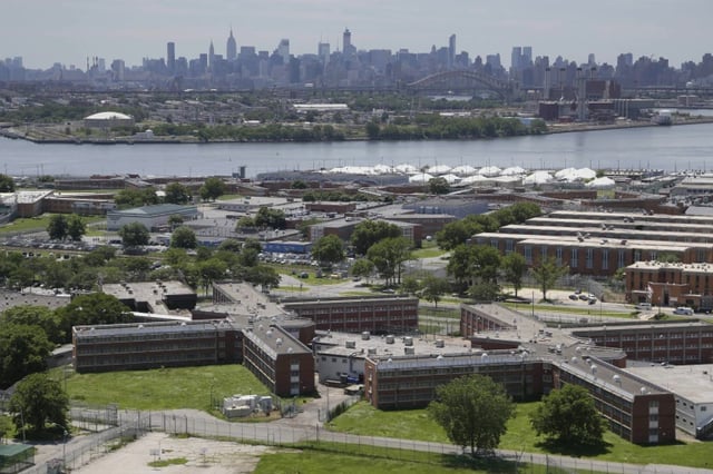 The Rikers Island jail complex stands with the Manhattan skyline in the background, June 20, 2014, in New York.