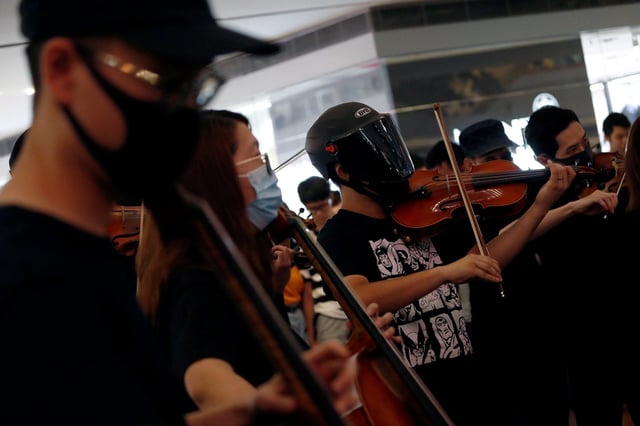A group of musicians play "Glory to Hong Kong," during a flash mob protest inside a shopping mall at Kowloon Tong, in Hong Kong on September 18, 2019.