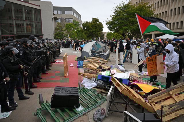 Pro-Palestinian demonstrators confront police as they clear an encampment after students occupied the Physical Sciences Lecture Hall at the University of California, Irvine, in Irvine, California on May 15, 2024.