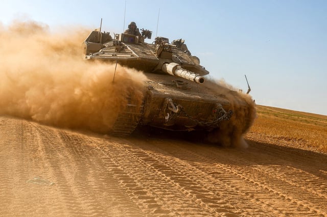 An Israeli army battle tank moves near the border with the Gaza Strip at a location in southern Israel on May 13, amid the ongoing conflict in the Palestinian territory between Israel and the Hamas movement.