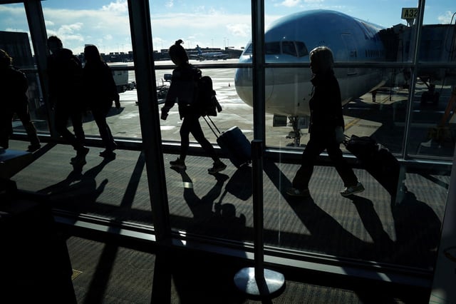 Passengers make their way through the terminal as they travel ahead of the Thanksgiving holiday at Washington Dulles International Airport in Dulles, Va., on Nov. 22, 2023.