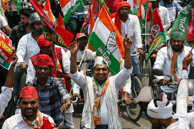 Congress supporters wave the party flag during a campaign rally in Varanasi on May 10. The Congress campaign has not been without controversy. Photo: AFP