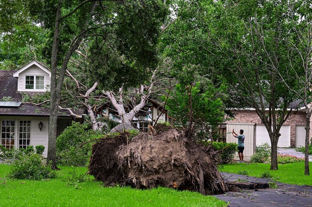 A home is severely damaged by a fallen tree after heavy winds and rains ripped through the region in Houston, Texas, on Friday.