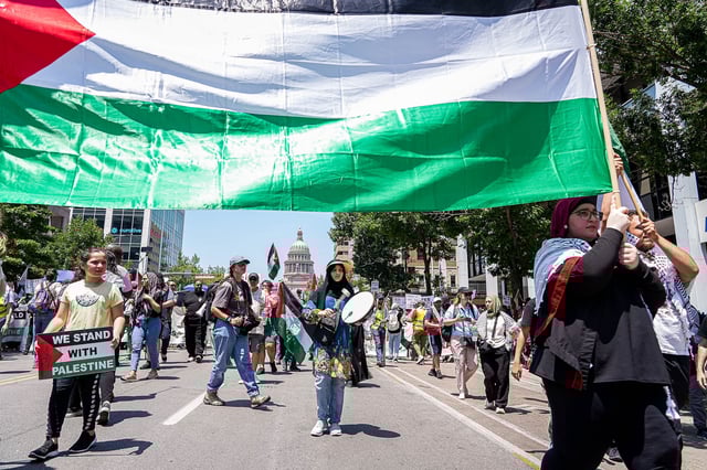 Protesters carrying a Palestinian flag march down Congress avenue at a pro-Palestine protest on Sunday, May 19, 2024 in downtown Austin. Hundreds of protesters gathered to protest the war in Gaza at to commemorate the 76th anniversary of the Nakba, the day Palestinians were displaced from their homelands 1948.