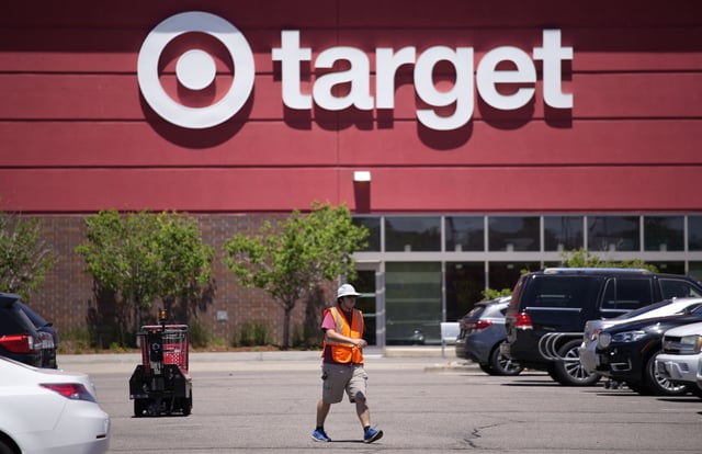 A worker collects shopping carts in the parking lot of a Target store June 9, 2021, in Highlands Ranch, Colo. Target says it's cutting prices on about 5,000 food, beverage and household essential items, becoming the latest company to shift its pricing strategy as consumers pay closer attention to how they spend their money amid inflation concerns.(AP Photo/David Zalubowski, File)