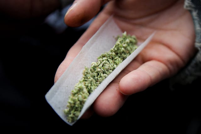 A person prepares a marijuana cigarette in New York City on April 20, 2024.