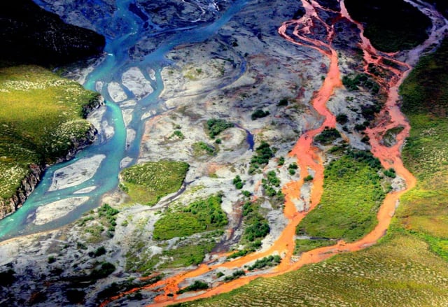 An aerial view of the rust-colored Kutuk River in Gates of the Arctic National Park in Alaska. Thawing permafrost is exposing minerals to weathering, increasing the acidity of the water, which releases metals like iron, zinc and copper. (Credit: Ken Hill / National Park Service)