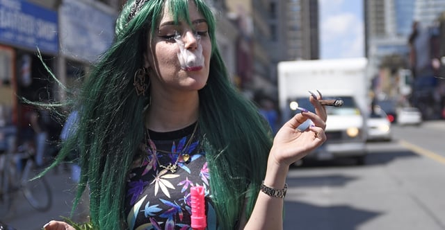 A study links teens' marijuana use to increased risk of psychosis, prompting some to suggest that young people delay use of the drug. Pictured: A teenage girl smokes a joint during a march in Toronto on May 5, 2018, a few months before Canada legalized marijuana. (Photo: Arindam Shivaani/NurPhoto via Getty Images)