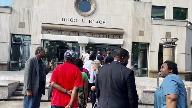 A line of people wait outside the federal courthouse in Birmingham, Ala., on Monday, Aug. 14, 2023. to watch the Aug. 14, 2023 hearing. A three-judge panel is reviewing Alabama's new congressional districts. They will decide whether to let the map stand or step in and draw districts for the state. (AP Photo/Kim Chandler)