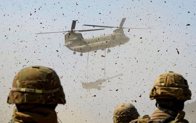 A US Army helicopter transports a howitzer during a joint military drill between South Korea and the United States on March 19, 2023. Photo: AP