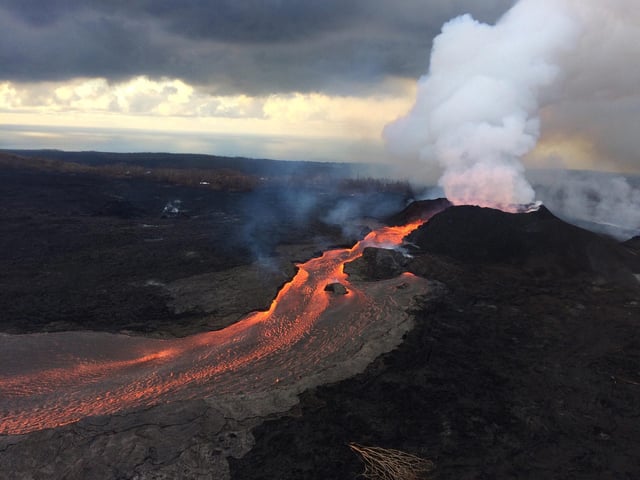 Lava flow on the eastern flank of Kilauea, fed by magma draining from underwater reservoir. At fissure 8, fountains provide a vigorous supply of lava that exits the cinder cone and drops over a spillway to enter a well-established lava channel that extends to the sea. Credit: USGS