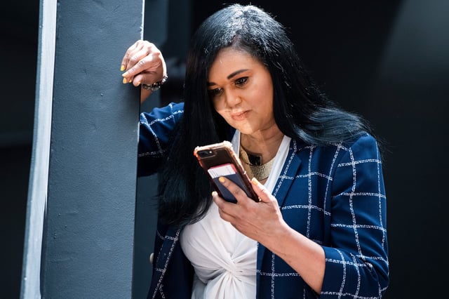 Rep. Shawn Thierry looks down at her phone