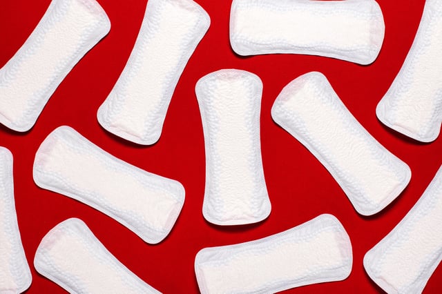 Menstruation. Pile of white pads liners on red background