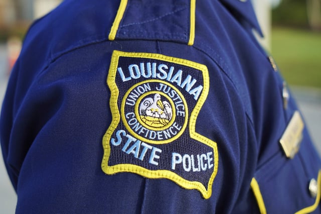 A Louisiana State Police trooper attends the funeral of a colleague in Baton Rouge, La., on Oct. 16, 2021.