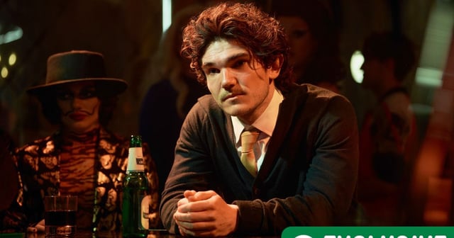 Andy sat at a bar - with a green RT exclusive banner in the bottom right corner