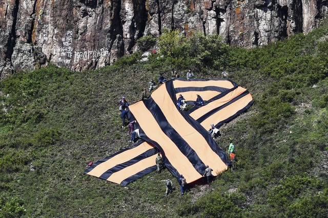 People hold a big ribbon of Saint George on a mountain slope to mark the 75th anniversary of the victory over Nazi Germany in the Great Patriotic War, in the town of Divnogorsk, Russia, on May 6, 2020.