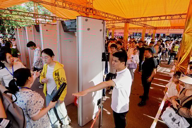 Students line up to pass a security check outside a school on the first day of "gaokao" in Bozhou, China, on June 7, 2024.