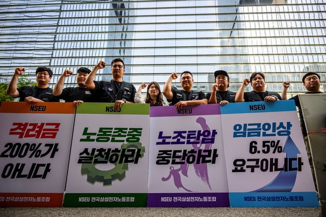 Samsung Electronics' union members hold placards during a rally outside the company building in Seoul on June 7, 2024, as workers at the tech giant staged the first ever strike.