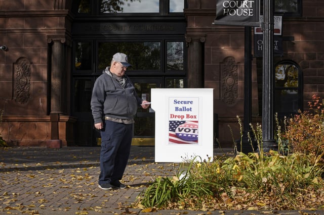 A voter places a ballot in a drop box in Fargo, North Dakota, on Oct. 15, 2020.
