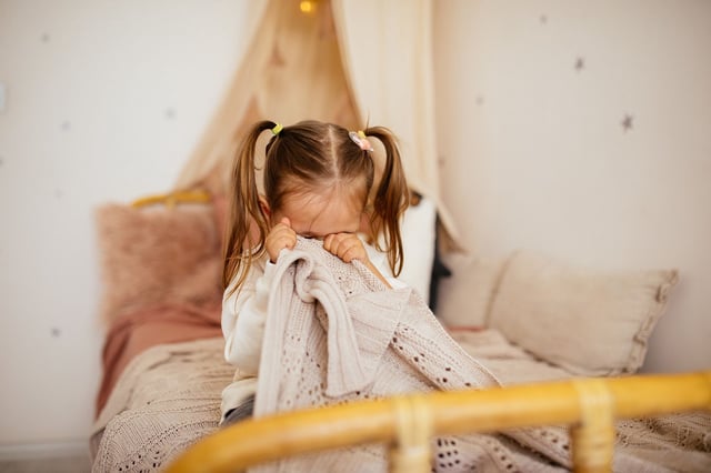 Portrait of unhappy small girl indoors, crying.