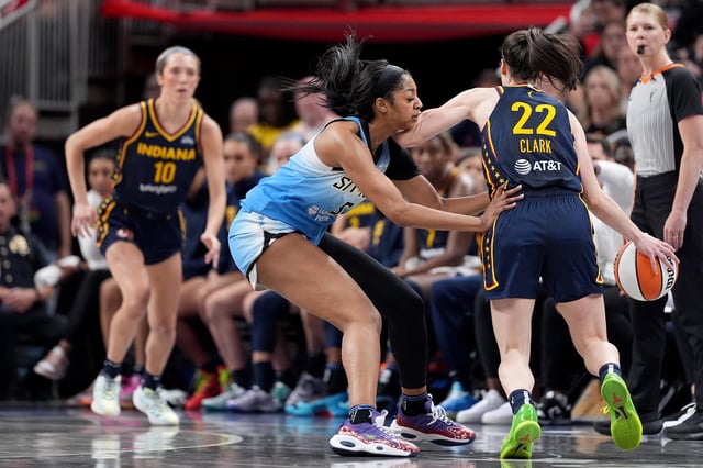 Angel Reese hand-checks Caitlin Clark during Sunday's game between the Chicago Sky and Indiana Fever in Indianapolis.
