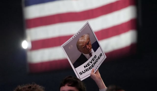 A supporter holds up a placard as Republican presidential candidate and former President Donald Trump speaks at a campaign event Saturday, June 15, 2024, in Detroit. (AP Photo/Carlos Osorio)