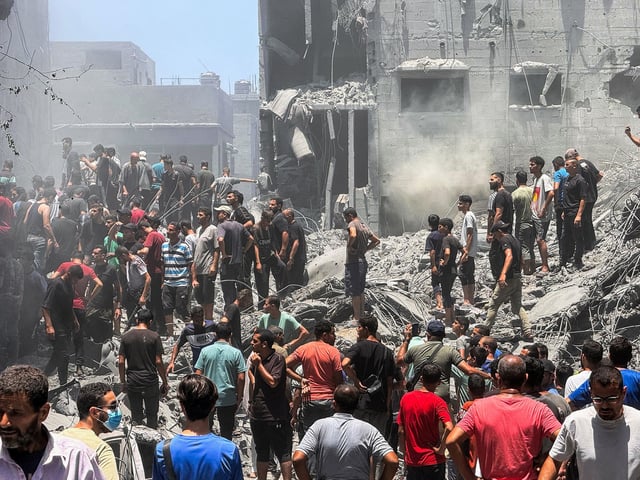 Palestinians search for casualties at the site of Israeli strikes on houses in Gaza City on Saturday.