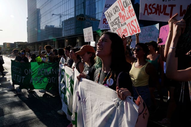 Demonstrators supporting abortion rights march down a street on June 24, 2022, in Austin, Texas.