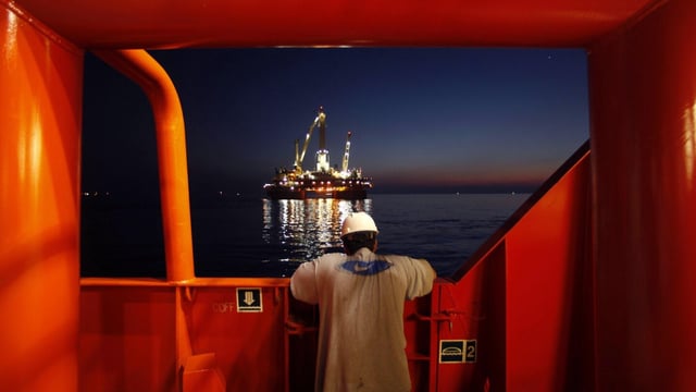 FILE - Wilson Ruiz, a crew member of the Joe Griffin, looks out at the oil slick at the site of the BP Deepwater Horizon offshore oil rig collapse in the Gulf of Mexico on May 6, 2010. The Biden administration has tightened offshore oil drilling safety regulations, including rules regarding the use of “blowout preventer” devices on offshore oil and gas drilling rigs. Planned changes announced last fall were finalized Tuesday, Aug. 22, 2023 — more than 13 years after the BP Deepwater Horizon disaster that killed 11 workers and spewed an estimated 130 million gallons of oil into the Gulf of Mexico. (AP Photo/Gerald Herbert, File)